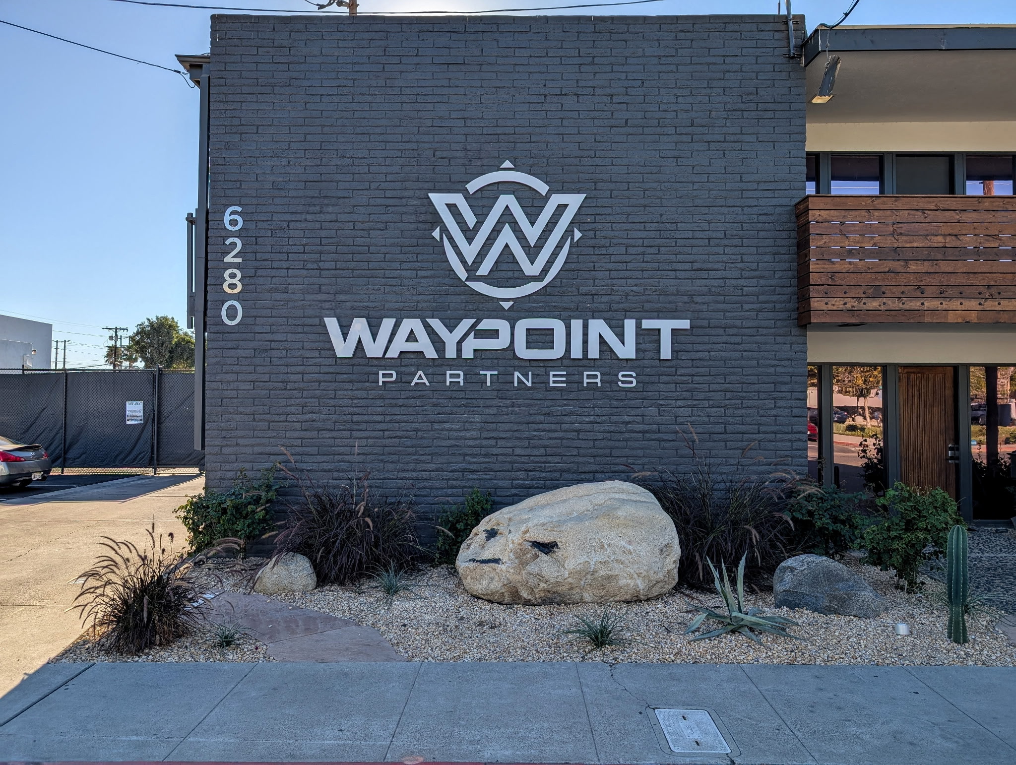Dimensional Waypoint Partners wall sign installed on an exterior brick façade